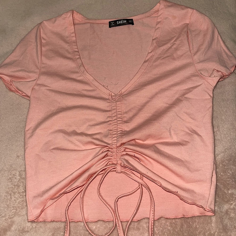 Light pink crop top with strings in front to adjust crop